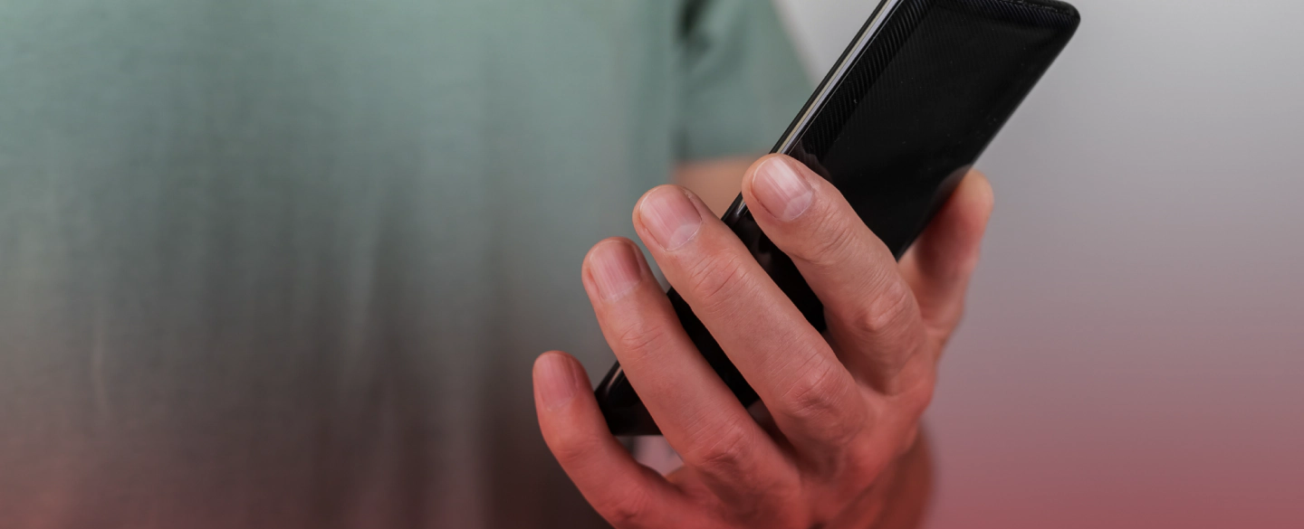 man holding a black cellphone with his left hand